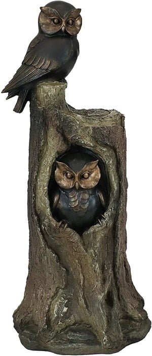 statue of two owls - one in hollow of a tree, other on tree stump