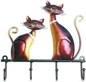 two large cats perched atop this key rack that holds 4 keys
