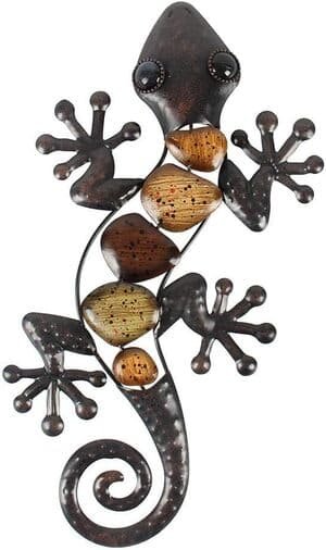 a metal wall hanging of a gecko with stones forming the body