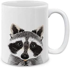 mug with a raccoon painted. The raccoon appears to be eating something